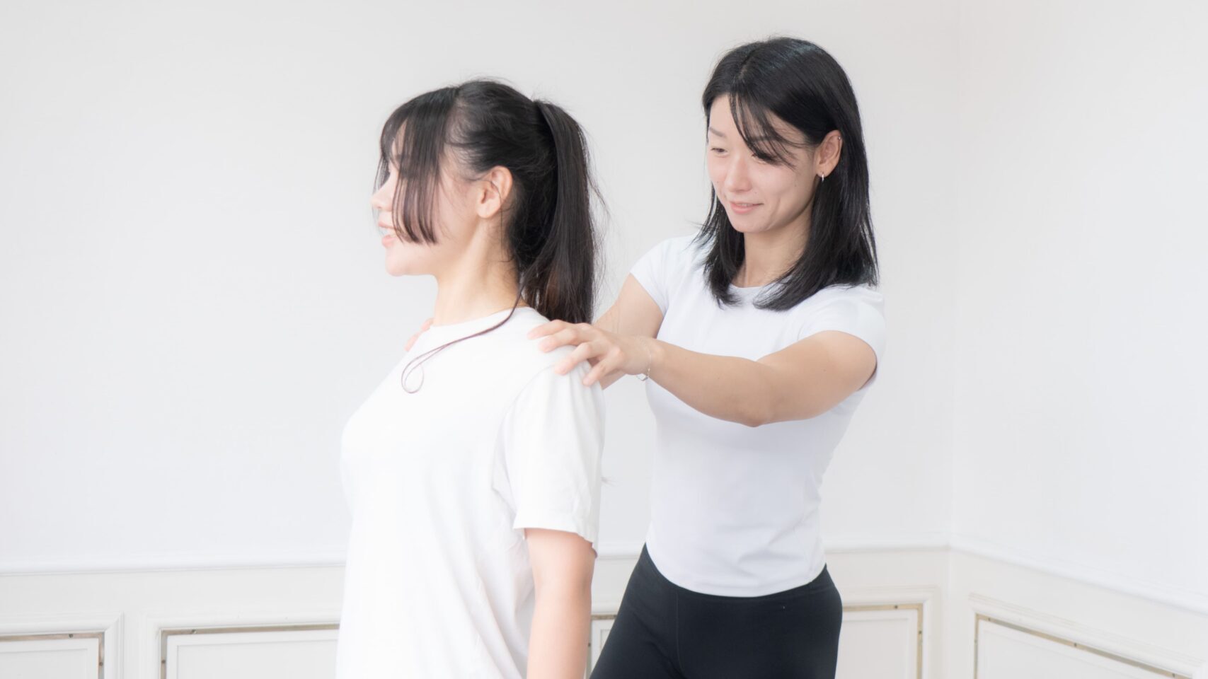 ピラティスインストラクターに姿勢分析を受けている女性